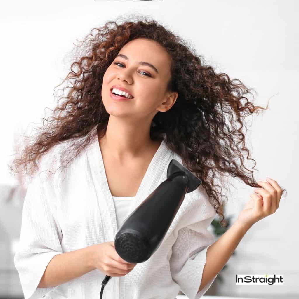 lady blow drying her natural curly hair